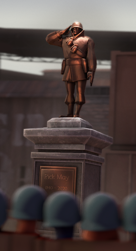 Obrázek památníku Ricka Maye v podobě bronzové sochy ve hře TF2